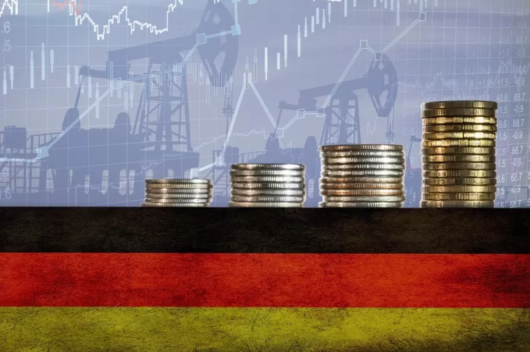 Coins on top of the flag of Germany on the background of oil rigs and charts. Concept - increase in the cost of gasoline, diesel, energy in Germany. Increase in the selling price of hydrocarbons.<br>njemačka, inflacija, rast cijena, tro&scaron;kovi, porast tro&scaron;kova, industrija, proizvodnja