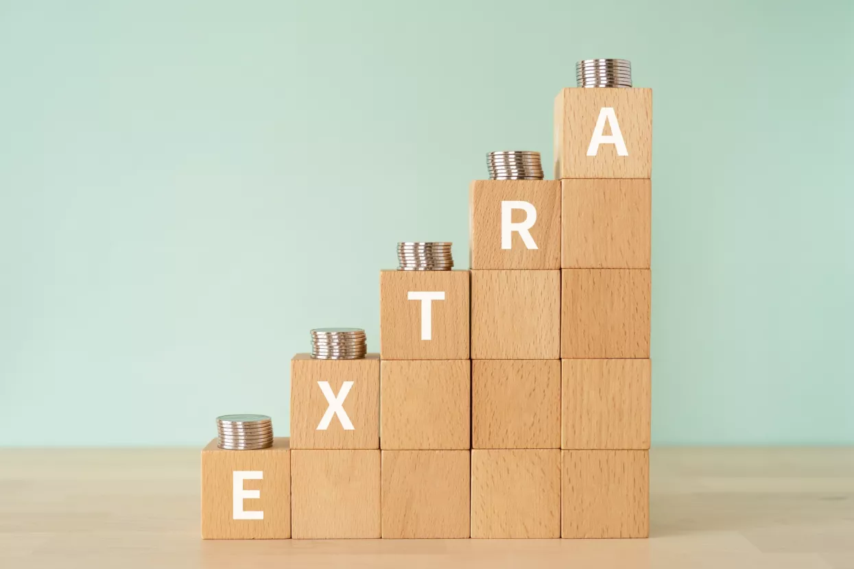 Wooden blocks with "EXTRA" text of concept and coins.
