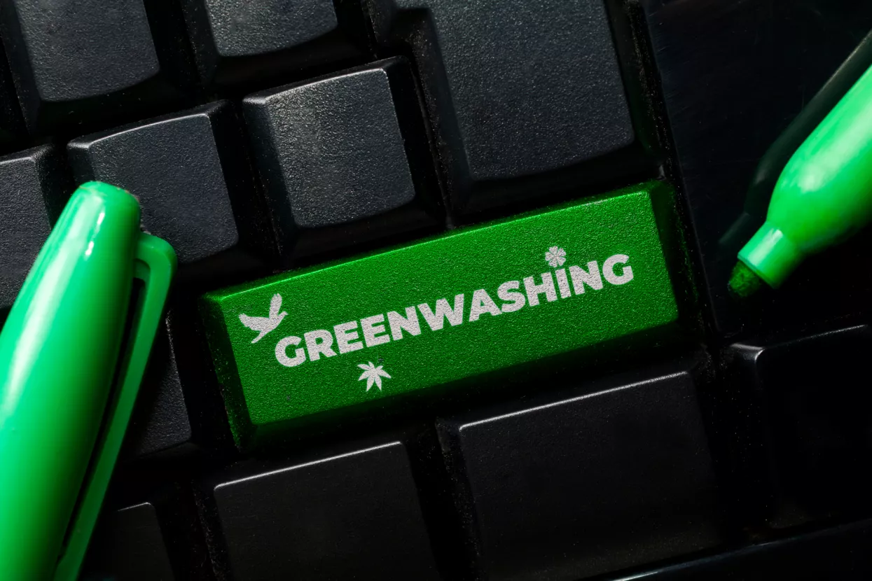 Greenwashing concept: a black keyboard with a green marker and the text greenwashing. Greenwashing is a communication technique to build a false image of a company in terms of environmental impact.