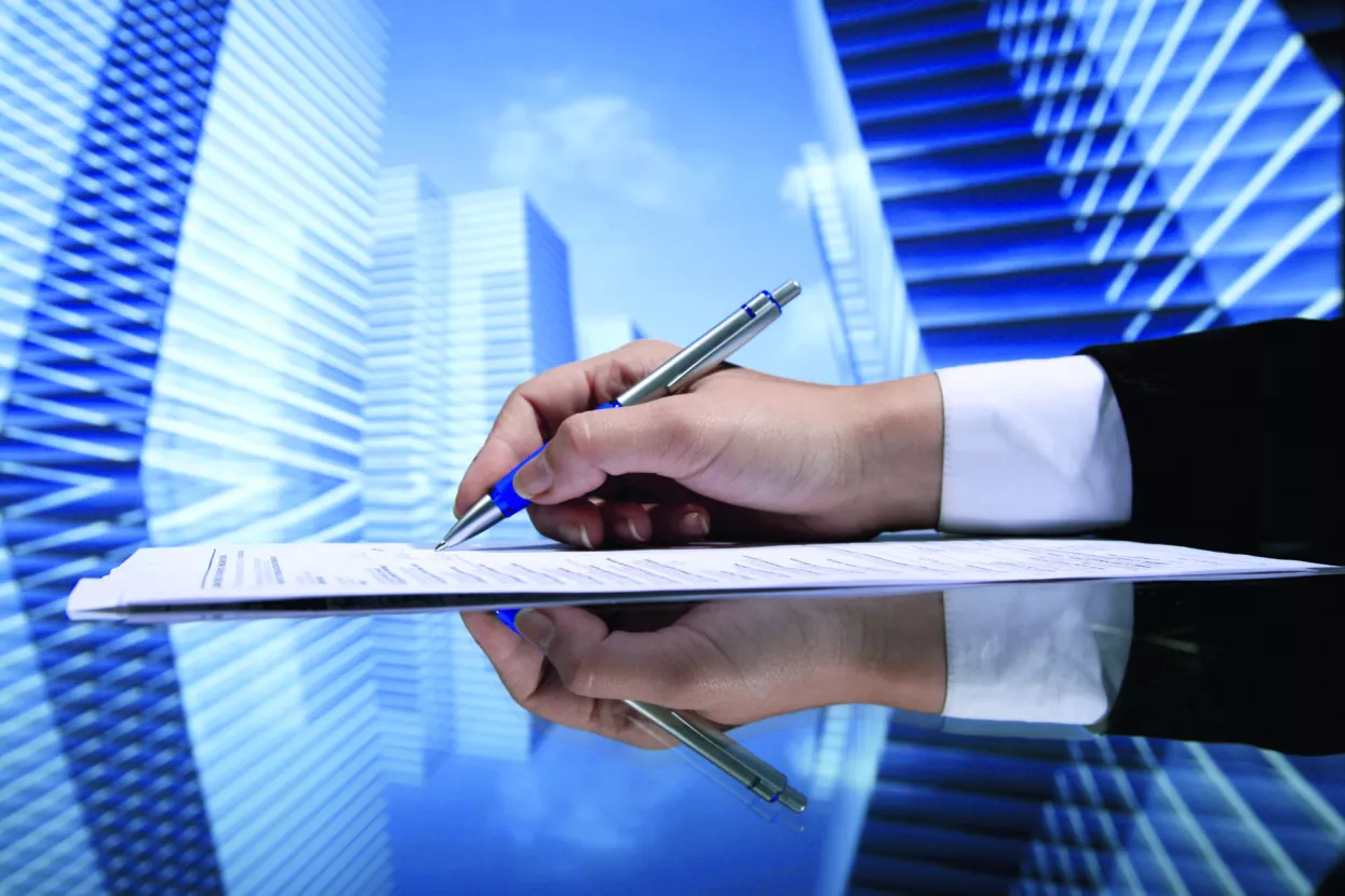 Realtor signing contract on skyscrapers background
