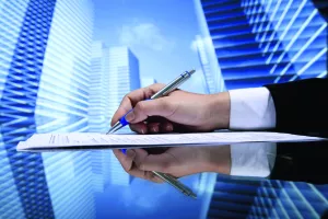 Realtor signing contract on skyscrapers background