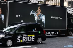 TOKYO, JAPAN - August 4, 2022A taxi passes a large advertising truck promoting Beyonce's new album in Tokyo's Ginza area. Ginza Place is in the background. Some motion blur. Renaissance