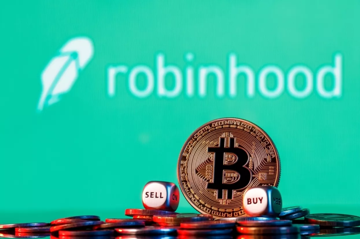 Kazan, Russia - Oct 19, 2021Robinhood Markets is an American broker-dealer company. Golden bitcoin with two buy-sell cubes in a pile of coins on the background of the Robinhood logo.