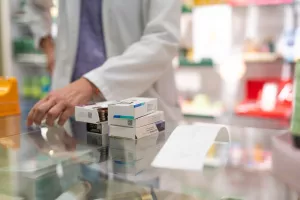 Medications stacked on a pharmacy counter, ready to be sold. Represents a typical scene in the daily routine of a pharmacyljekarništvo, farmacija, ljekarne, ljekarnici