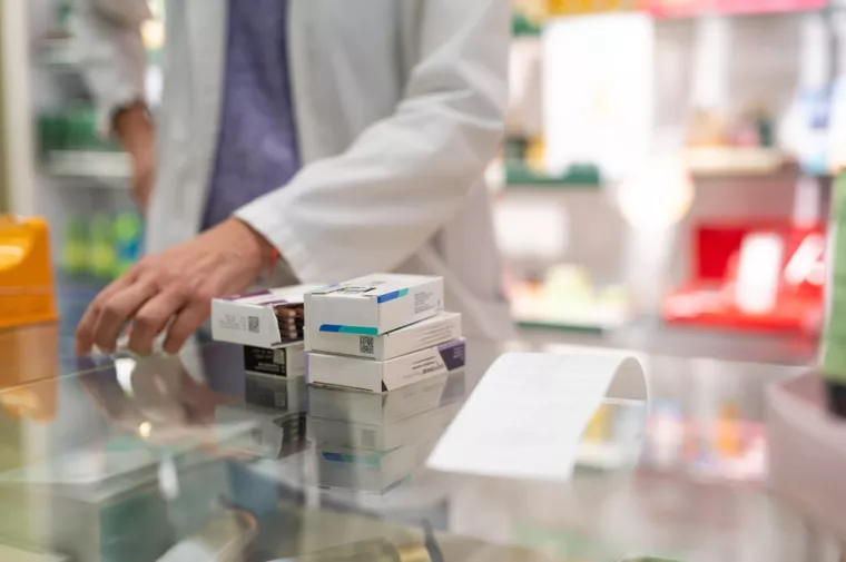 Medications stacked on a pharmacy counter, ready to be sold. Represents a typical scene in the daily routine of a pharmacyljekarništvo, farmacija, ljekarne, ljekarnici