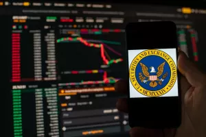 Kyiv, Ukraine - 06 June 2023Man holds a smartphone with SEC logo against the background falling Bitcoin chart on Binance - crash. S.E.C. Accuses Binance of Mishandling Funds and Lying to Regulators