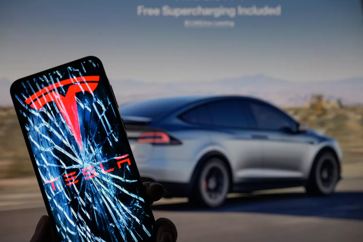 Tesla logo is displayed on a mobile phone with Tesla website in the background, seen in this photo illustration. Taken in Brussels, Belgium, On 9 February 2025. JRdes