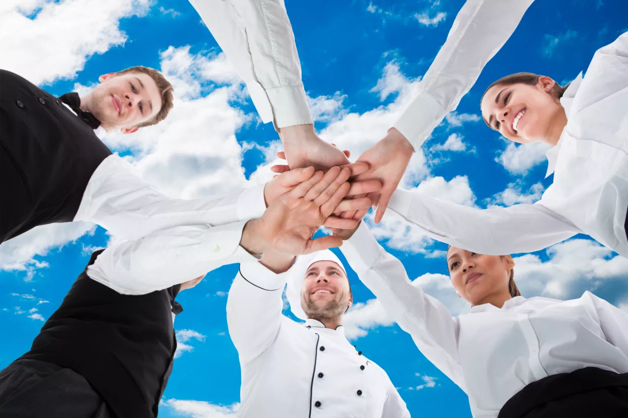 Low angle view of waiters and waitresses stacking hands against skyHoReCa Zadar promougostiteljstvo, konobari, kuhari