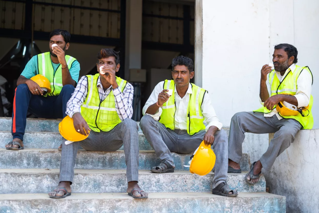 5-strani radnici - Group of Industrial workers having tea or coffee during break - concept of relaxation, coworkers and blue collar jobs