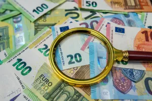Magnifying glass on euro bills, finance analysis, audit, banking and business investigation concept
